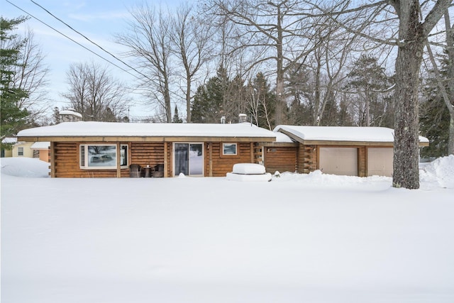 cabin with an attached garage and log siding