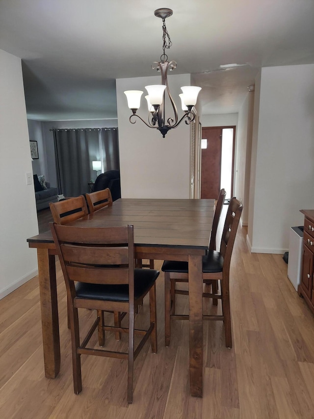 dining area featuring a notable chandelier and light hardwood / wood-style flooring