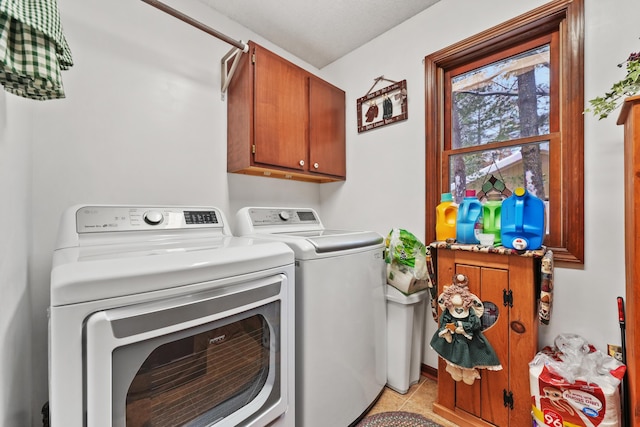 laundry area with cabinets, washer and clothes dryer, and light tile patterned floors