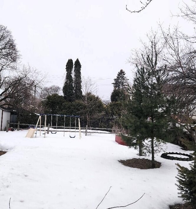 yard covered in snow with playground community