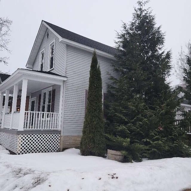 view of snow covered exterior with a porch