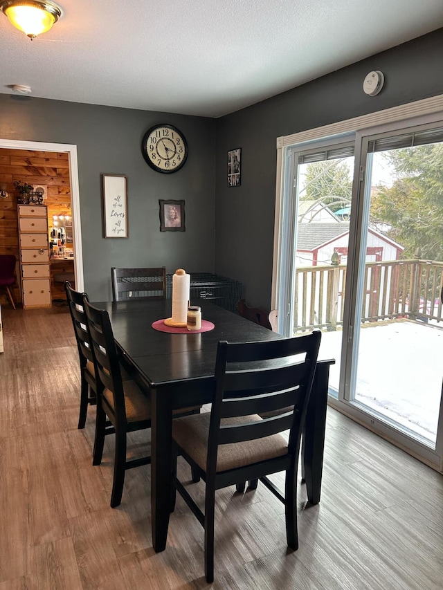 dining space with a textured ceiling and wood finished floors