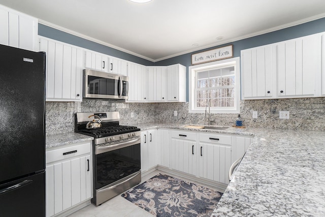 kitchen featuring crown molding, appliances with stainless steel finishes, white cabinets, and a sink