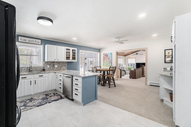 kitchen featuring glass insert cabinets, freestanding refrigerator, a peninsula, white cabinetry, and a baseboard heating unit