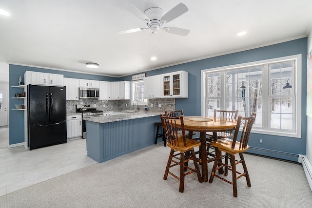 kitchen with white cabinets, appliances with stainless steel finishes, glass insert cabinets, a peninsula, and a sink