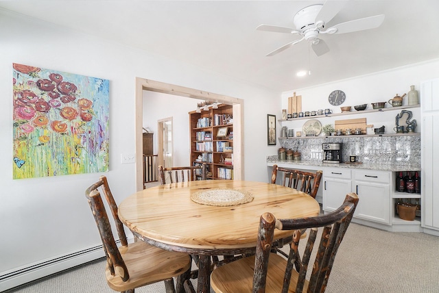 dining area with a baseboard heating unit, a ceiling fan, and light colored carpet