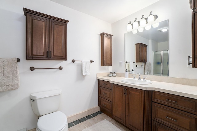 full bath featuring tile patterned flooring, toilet, a shower with shower door, vanity, and baseboards