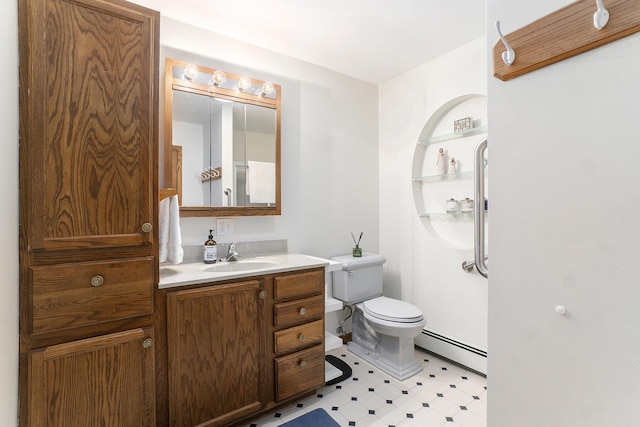 bathroom with a baseboard radiator, vanity, toilet, and tile patterned floors