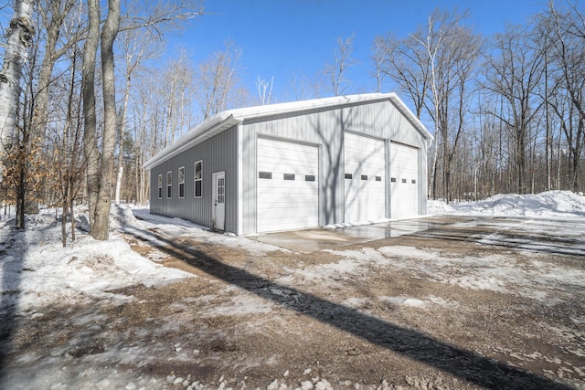 snow covered garage featuring a garage