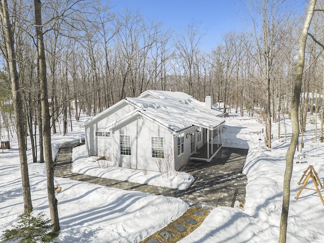 view of snow covered exterior featuring a chimney