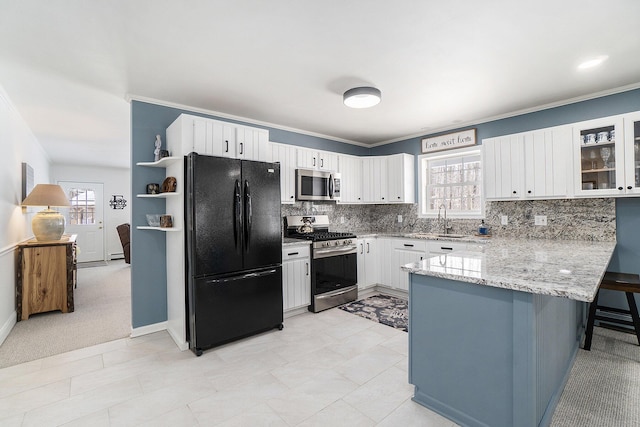 kitchen featuring stainless steel appliances, a peninsula, a sink, white cabinets, and glass insert cabinets