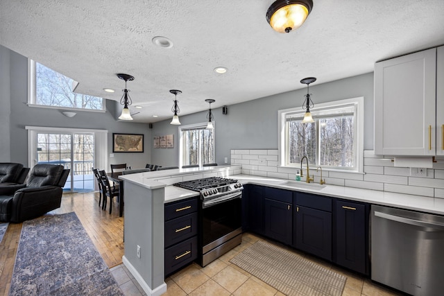 kitchen featuring a peninsula, pendant lighting, stainless steel appliances, and open floor plan