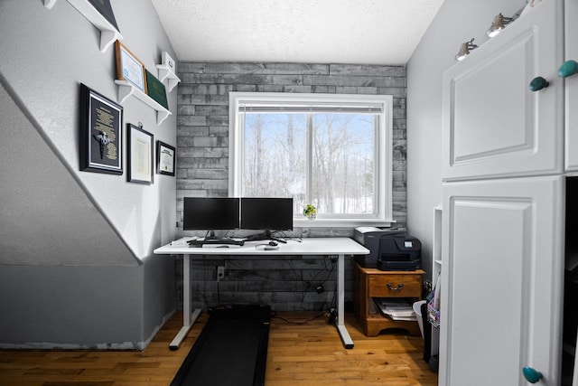 office area featuring light wood-type flooring and a textured ceiling