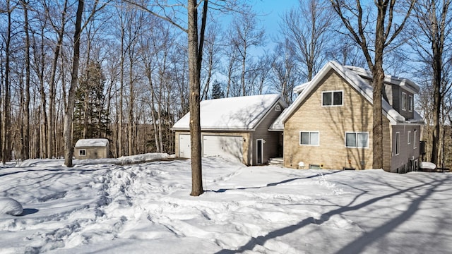 snow covered property with an attached garage