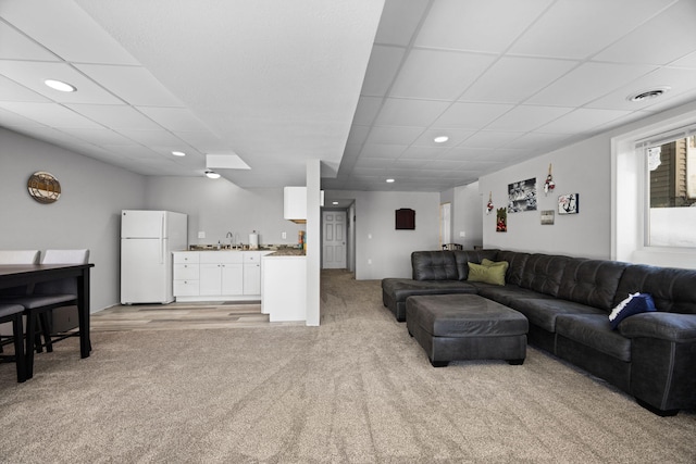 living area with a paneled ceiling, recessed lighting, light colored carpet, visible vents, and a bar