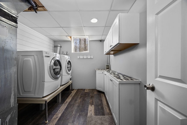 washroom featuring separate washer and dryer, dark wood finished floors, and cabinet space