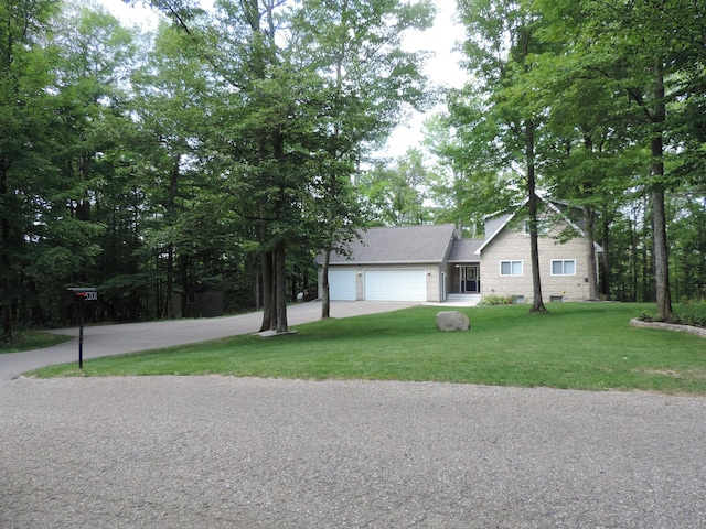 view of front facade featuring a garage, driveway, a shingled roof, and a front lawn