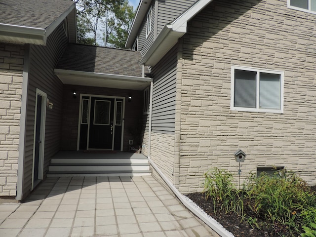 entrance to property with roof with shingles