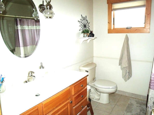 bathroom with a shower with shower curtain, vanity, toilet, and tile patterned floors