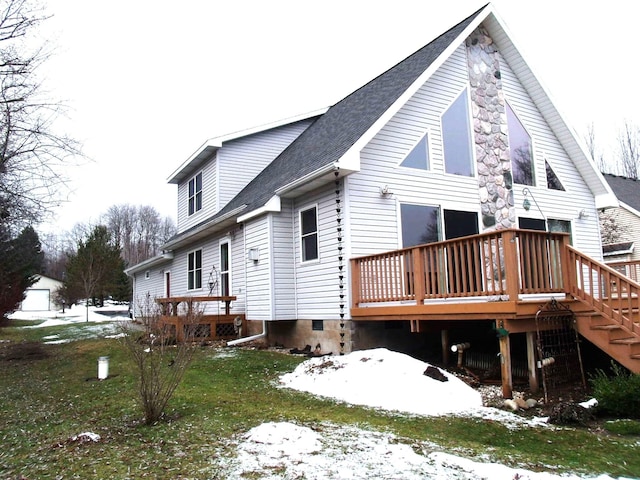 view of snow covered exterior featuring a shingled roof and a wooden deck