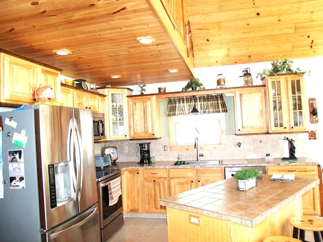 kitchen featuring tile countertops, wood ceiling, appliances with stainless steel finishes, and a sink