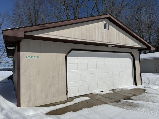 snow covered garage with a detached garage