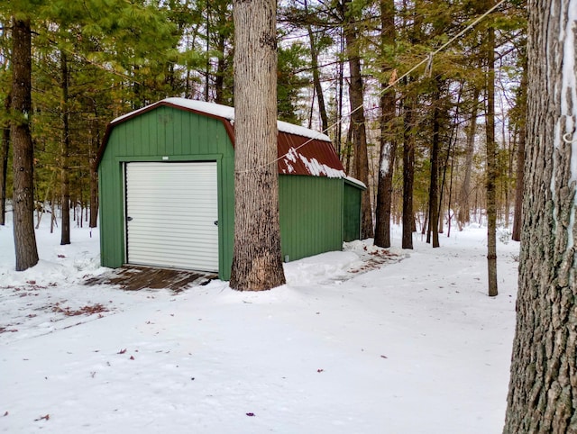 snow covered garage featuring a detached garage