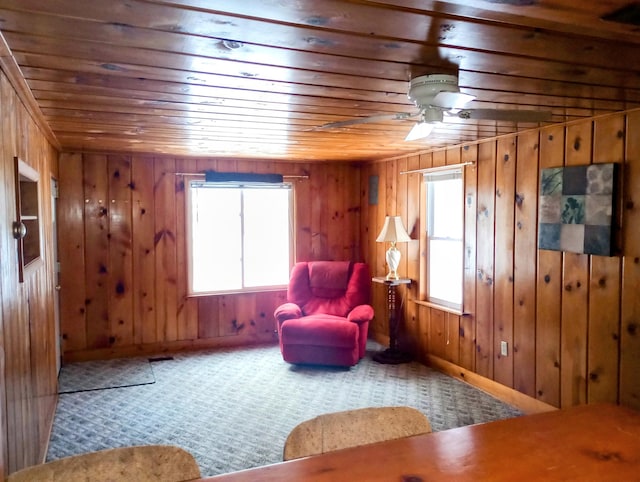 unfurnished room with wood walls, wood ceiling, a ceiling fan, and carpet flooring