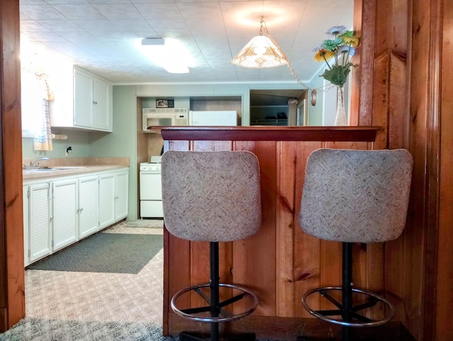 kitchen featuring light countertops, stove, a sink, and white cabinets