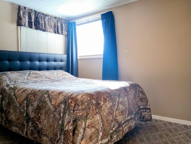 bedroom featuring dark colored carpet and baseboards