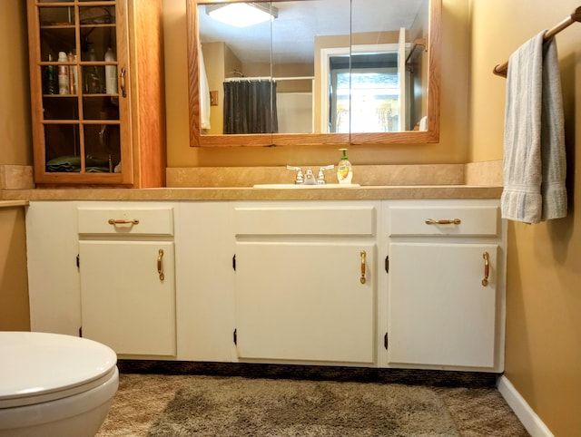 full bathroom with a shower with shower curtain, baseboards, toilet, and vanity