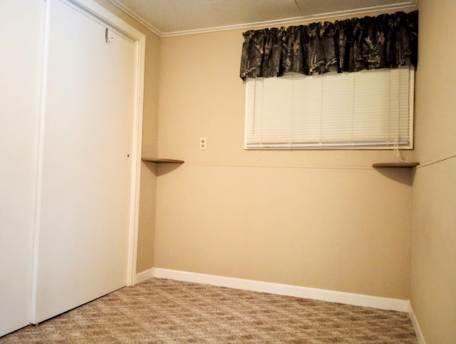 empty room featuring crown molding, baseboards, and carpet flooring