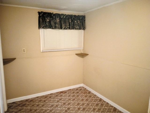 carpeted empty room featuring crown molding and baseboards