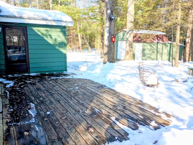 snow covered deck with a shed and an outdoor structure