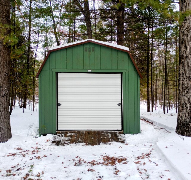 snow covered structure featuring an outbuilding