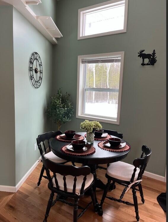 dining space featuring light wood-style flooring and baseboards