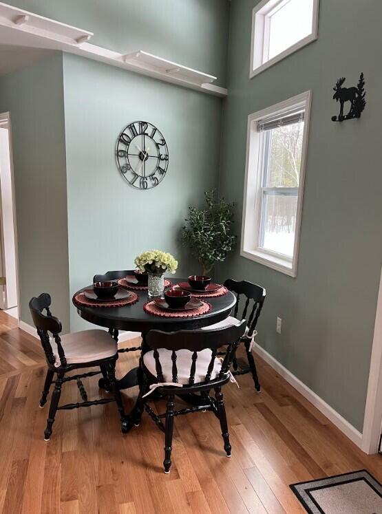 dining space with baseboards and wood finished floors