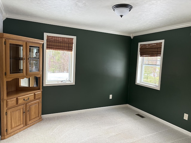 empty room with light carpet, visible vents, and a healthy amount of sunlight