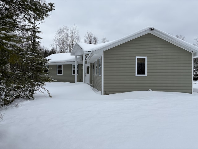 view of snow covered back of property