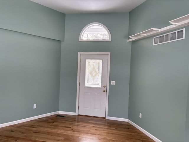 foyer entrance with visible vents, baseboards, and wood finished floors