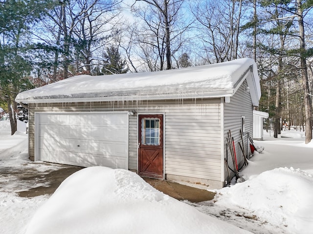 snow covered garage with a garage