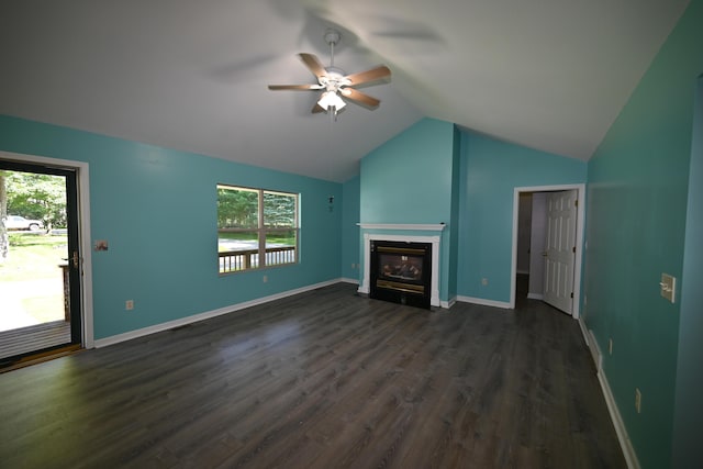 unfurnished living room with a ceiling fan, dark wood finished floors, vaulted ceiling, baseboards, and a glass covered fireplace