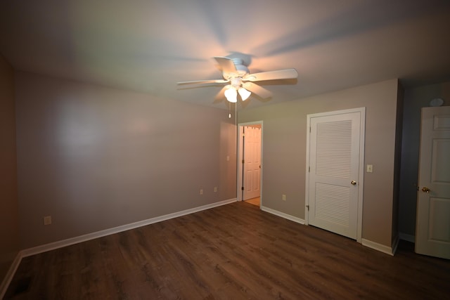 unfurnished bedroom featuring dark wood-style floors, a closet, ceiling fan, and baseboards