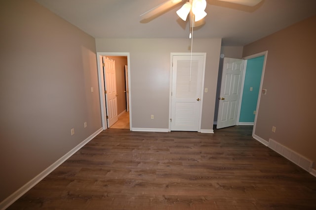 unfurnished bedroom with a ceiling fan, dark wood-style flooring, visible vents, and baseboards