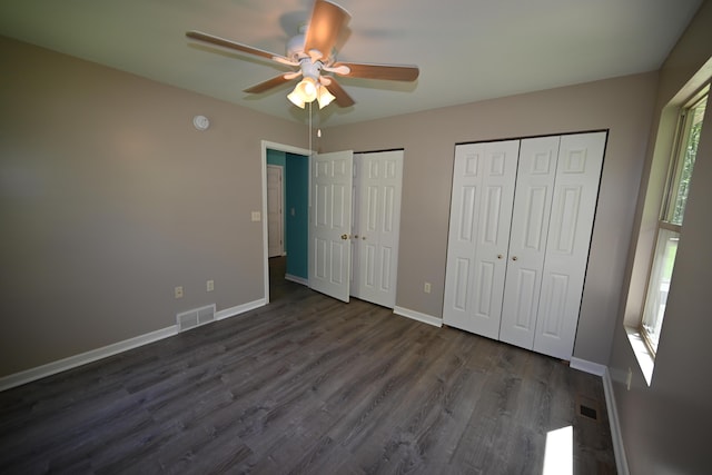 unfurnished bedroom featuring multiple closets, visible vents, and baseboards