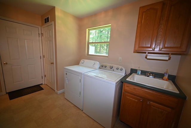 laundry area featuring light floors, visible vents, cabinet space, a sink, and washer and dryer