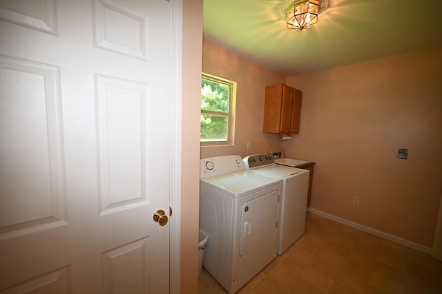 clothes washing area with cabinet space, baseboards, separate washer and dryer, and a sink