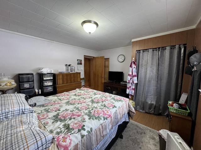 bedroom featuring wood finished floors and crown molding