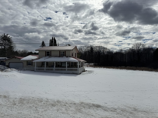 snow covered back of property with a garage