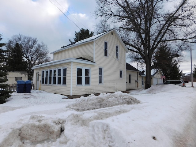 view of snow covered exterior featuring a detached garage